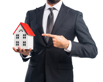Businessman holding a little house